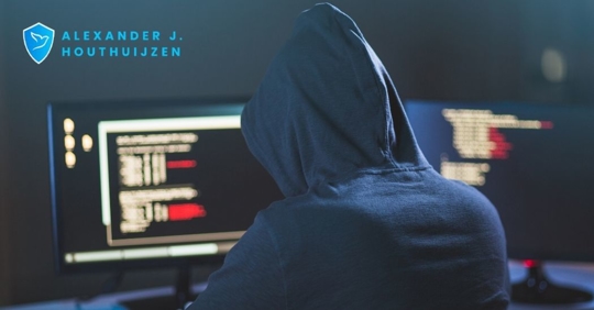 person in a hoodie in front of computers